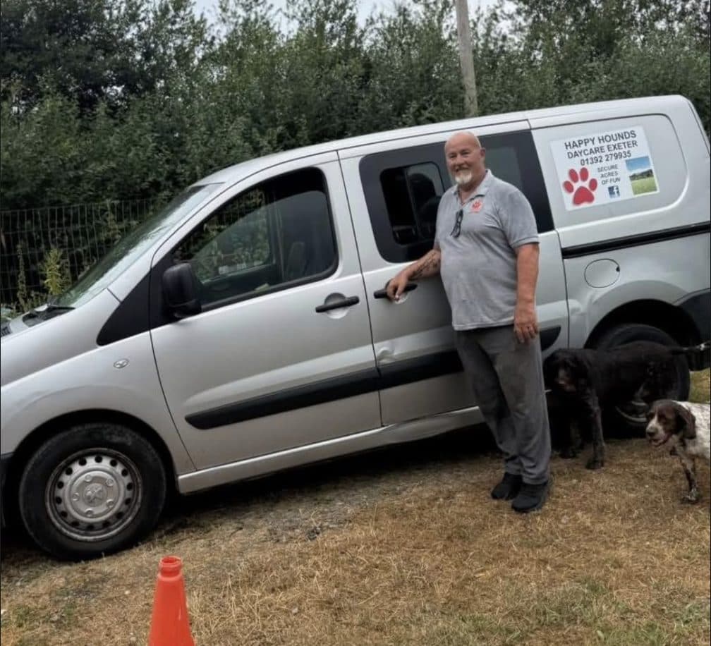 Brian standing beside the silver Happy Hounds van